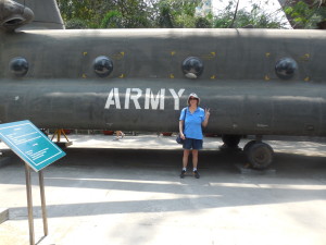 Red Cross Donut Dollies Mary (Blanchard) Bowe standing in front of a Boeing CH-47 Chinook Helicopter on display at the War Remnants Museum in Ho Chi Min City, Vietnam