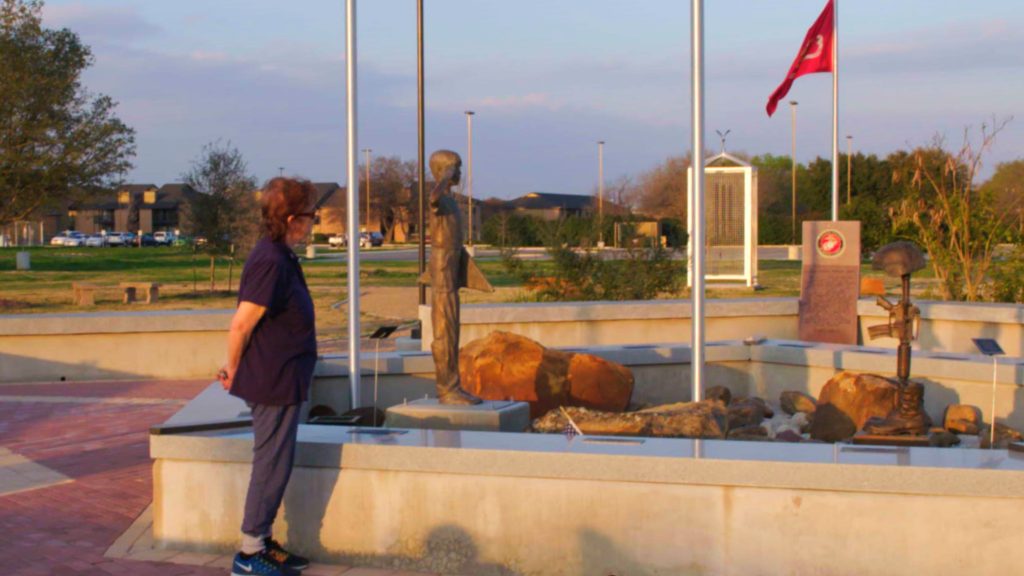 Donut Dollie Mary Blanchard Bowe taking a moment at the Veterans Memorial Plaza in Schertz, TX to honor those who serve and have served in the United States Armed Forces